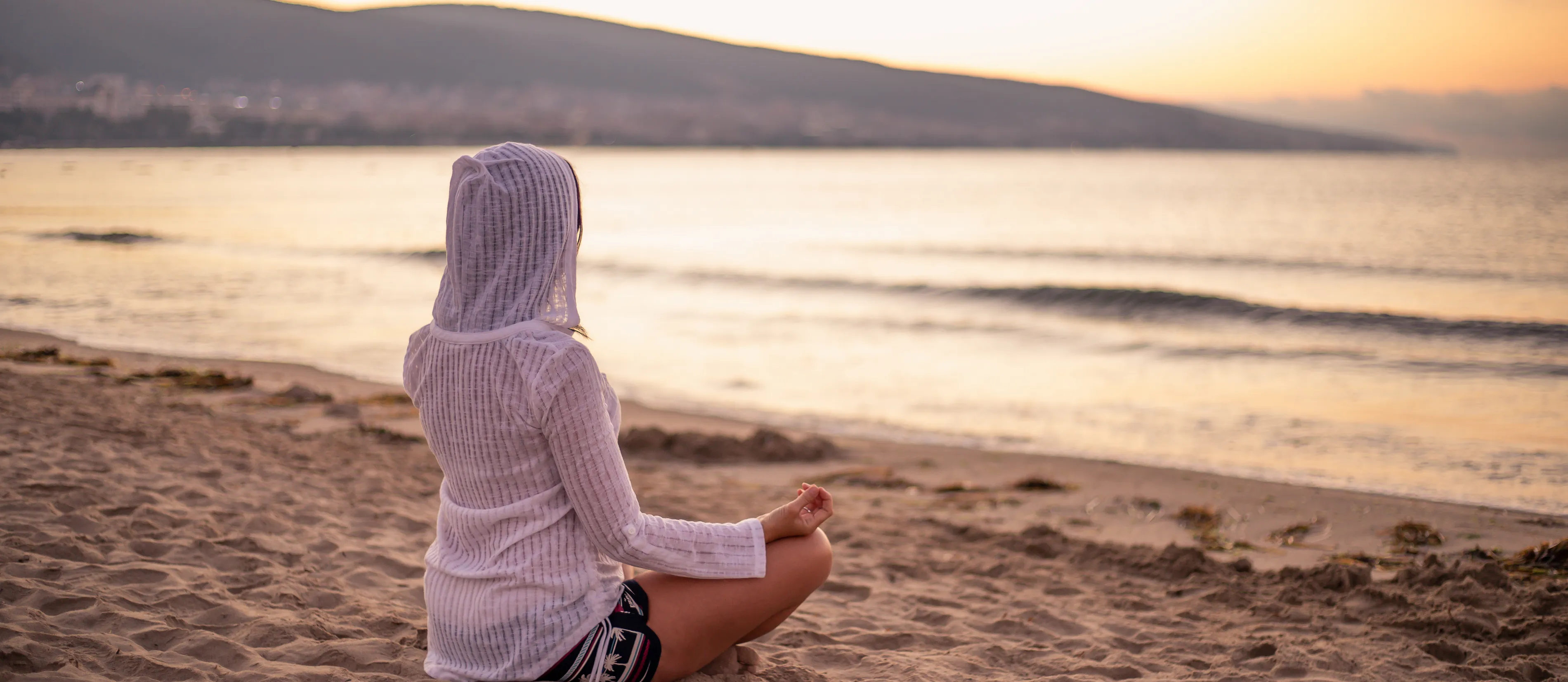Frau die am Strand meditiert